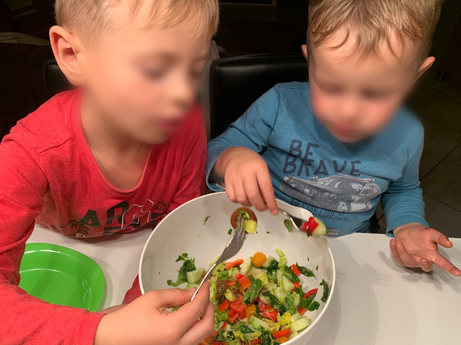 Zwei Kinder essen gemeinsam Salat